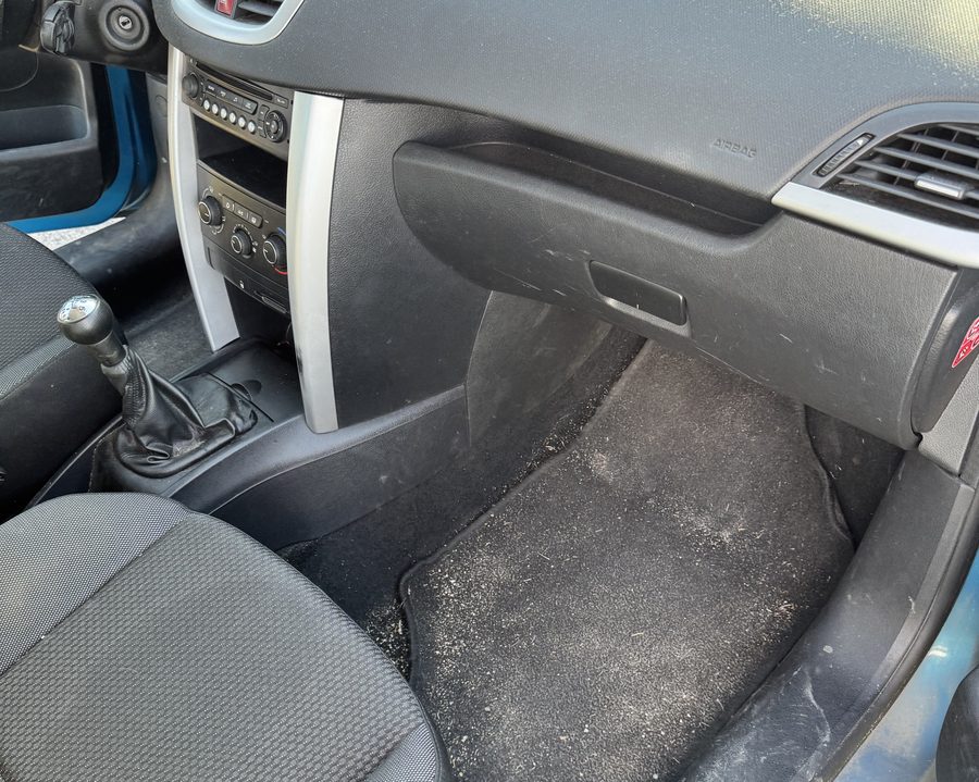 Le même intérieur avant : tapis couvert de poussière et de sable