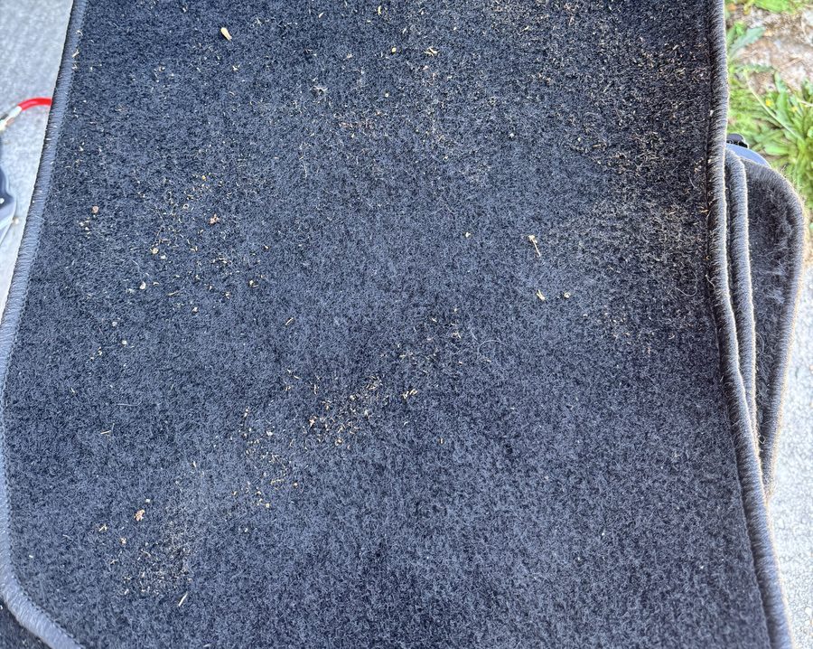 Tapis de sol avant nettoyage, avec débris et poussière incrustée